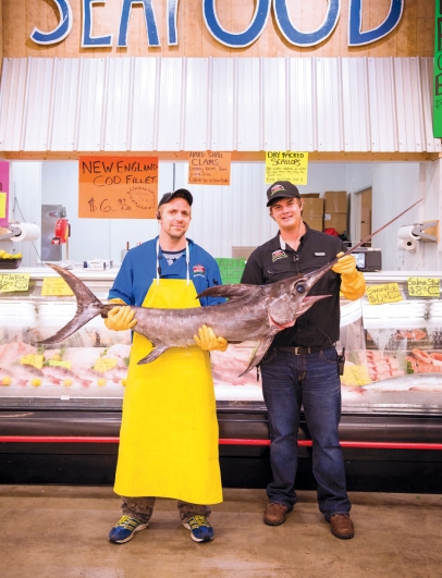 Sam Detwiler & seafood manager Dave Holman showing off their fresh Swordfish.
